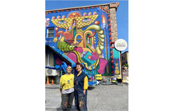Légende photo : L’artiste québécoise Danaé Brissonnet pose avec sa mère devant la murale qu’elles ont réalisée au 71, rue Eddy. L’œuvre a été commandée par la Ville de Gatineau afin de commémorer le centenaire du conflit ayant opposé les Allumettières à la E.B. Eddy. Crédit photo : Lily Ryan